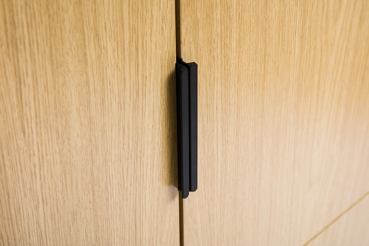 Gros plan sur poigne noire d'armoire chne GARENCE.