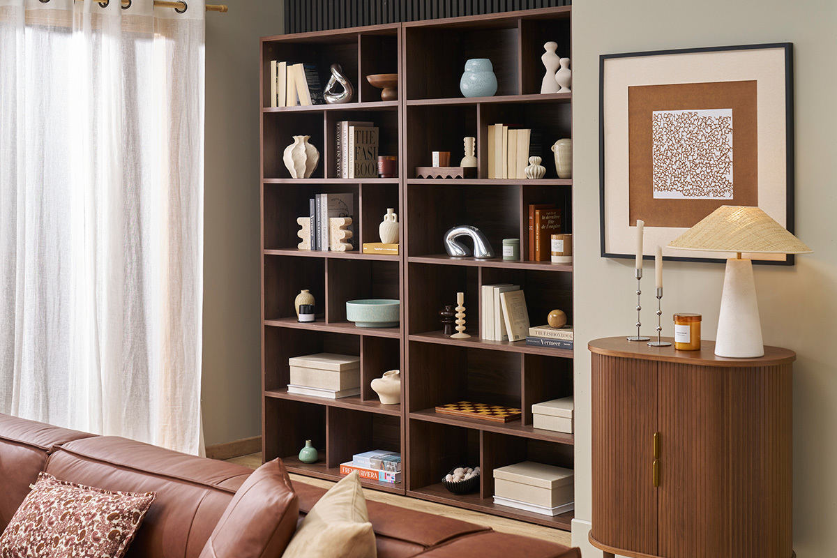 Bibliothque bois fonc noyer avec 12 casiers, livres et dcorations, vue d'intrieur.