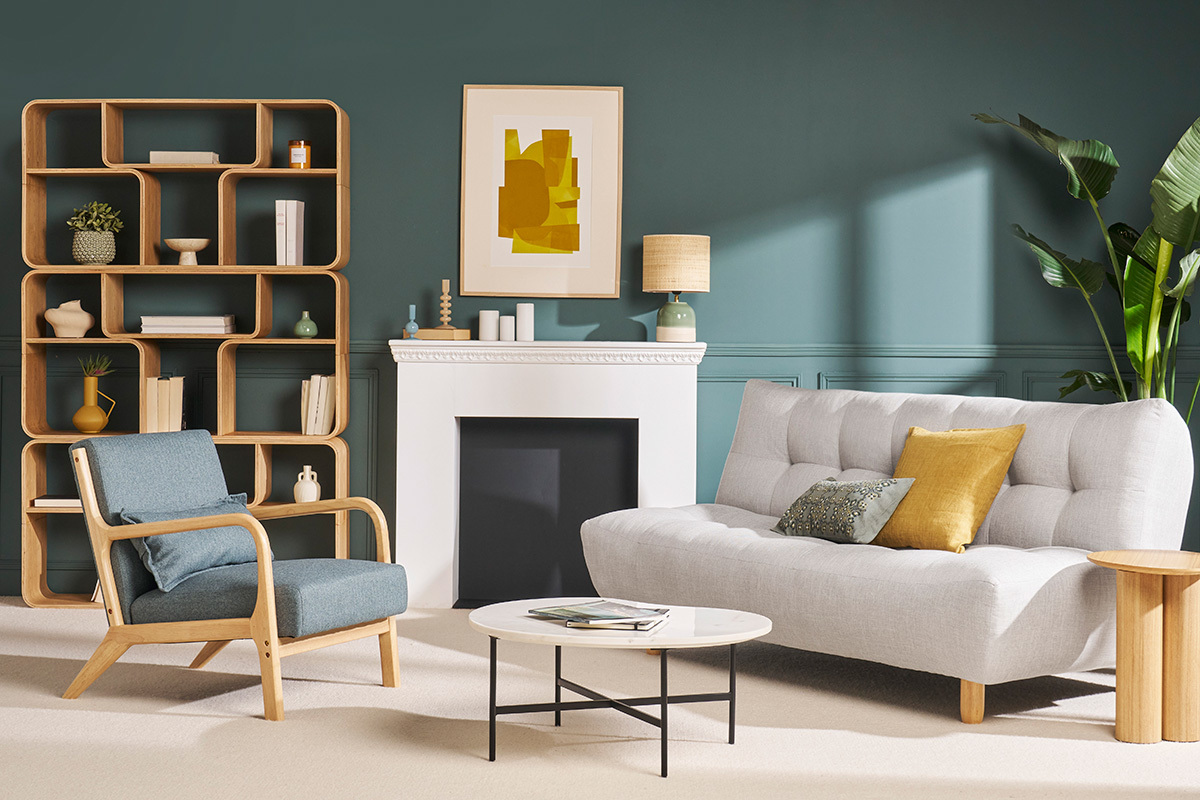 Biblioth�que en bois avec �tag�res, dans un salon moderne avec fauteuil bleu et canap� gris.