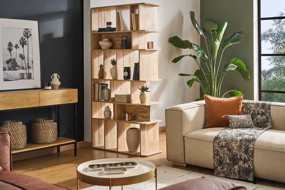 Biblioth�que en bois de manguier massif avec objets d�co et plantes en arri�re-plan, vue de profil.
