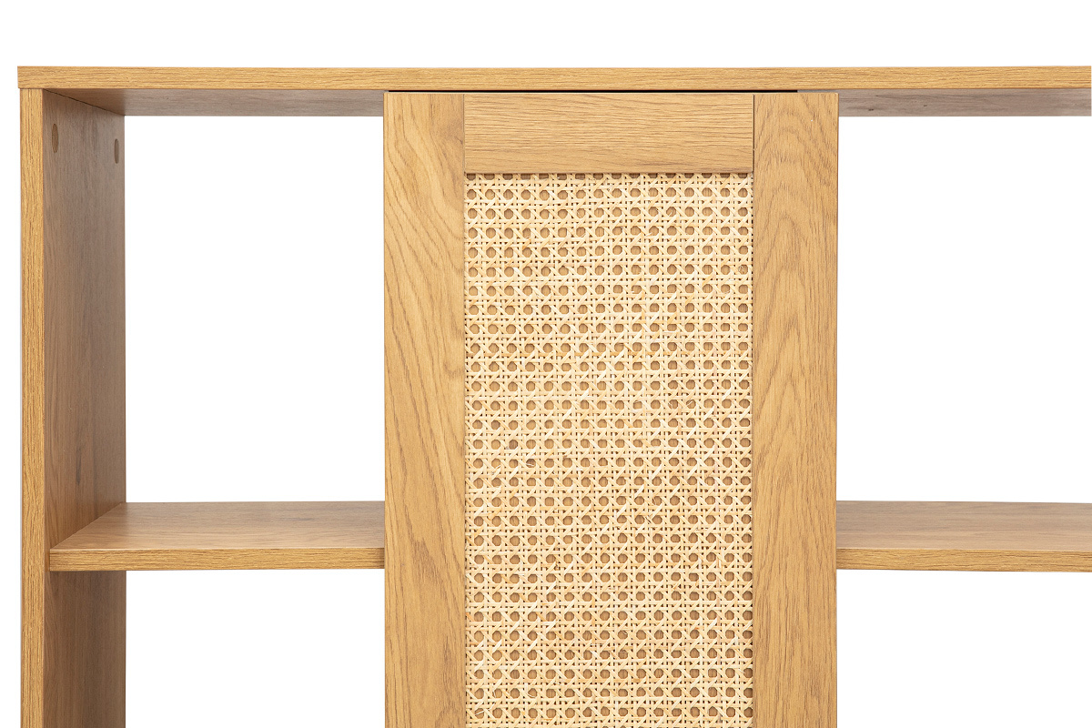 Gros plan sur bibliothque en bois clair avec panneau en cannage rotin, tagres visibles.