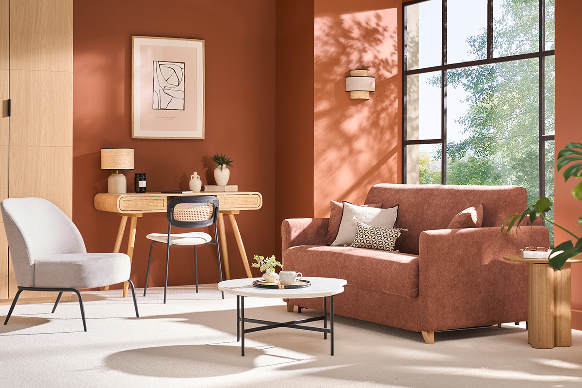 Canap convertible en tissu terre brle dans un salon avec bureau et fauteuil.