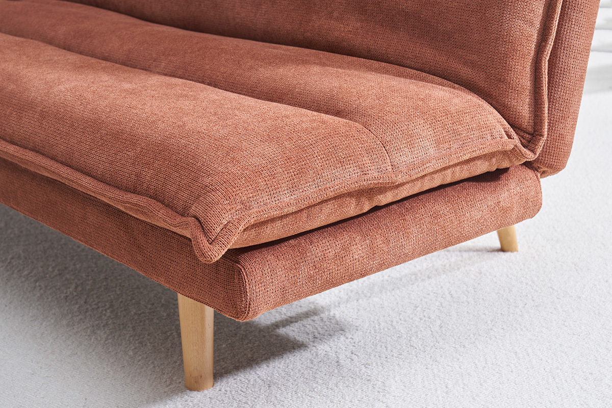 Dtail d'un canap convertible en tissu chenille terre brle avec pieds en bois clair, vue rapproche.