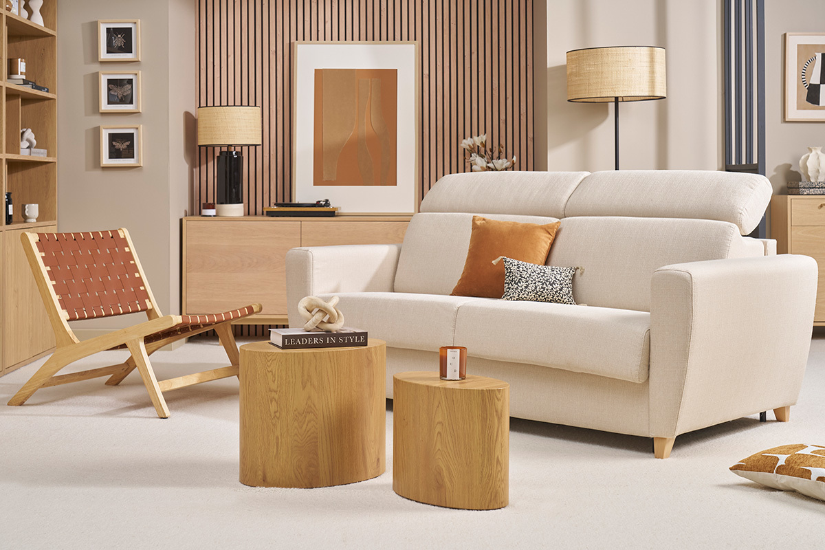 Canap convertible beige GOYA avec ttires ajustables, vue frontale, dans un salon avec meubles en bois clair.