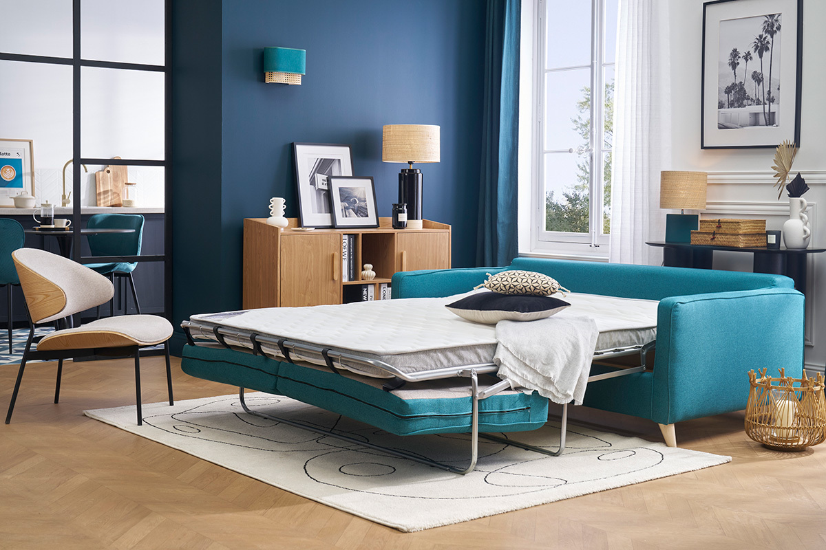 Canap convertible scandinave bleu canard, matelas dpli, vue d'intrieur moderne.