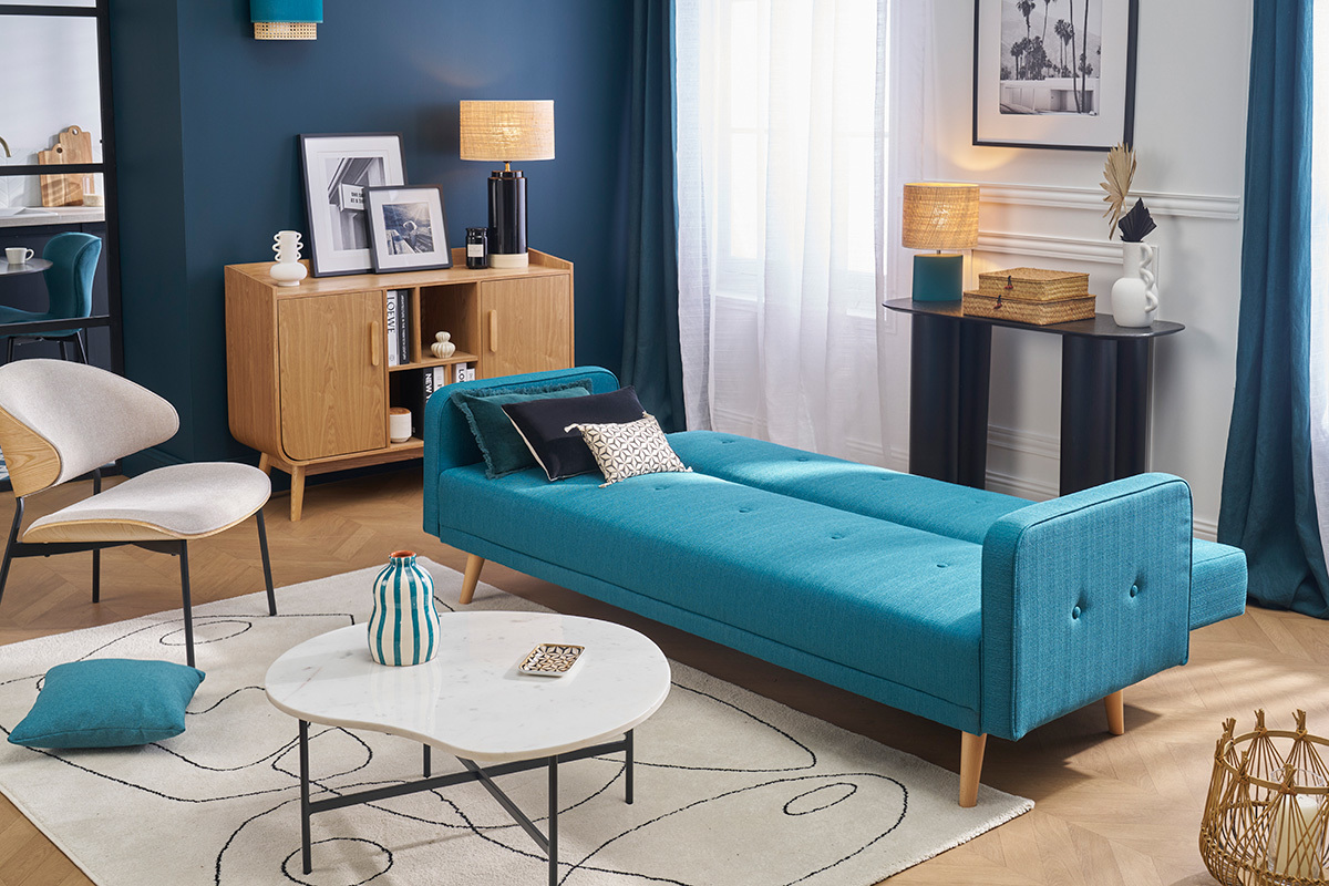Canap convertible scandinave bleu et bois clair en mode lit dans un salon moderne.