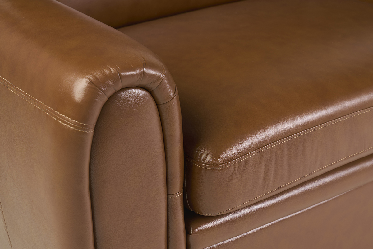 D�tail du canap� convertible vintage en cuir marron avec accoudoirs arrondis