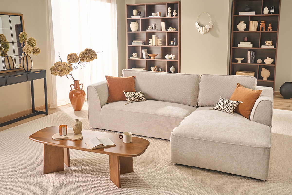 Canap� d'angle droit beige en tissu velours textur� avec coussins, table basse en bois.