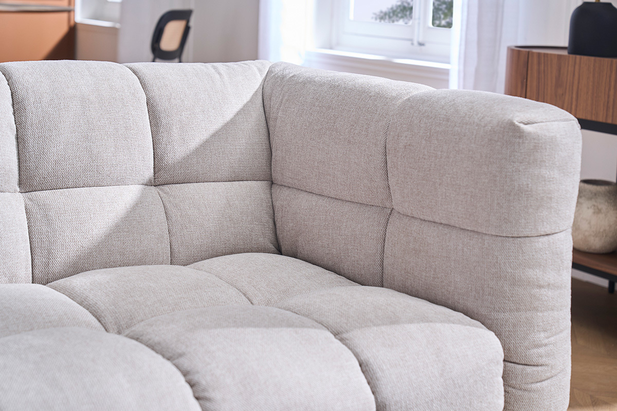 D�tail du canap� d'angle gauche CORTO en tissu effet velours textur� beige, angle visible.