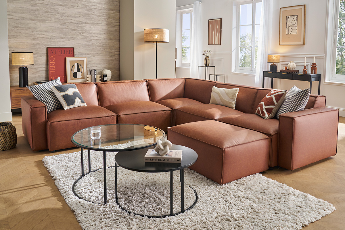Canap d'angle modulable 5 places avec pouf, beige, dans un salon moderne.
