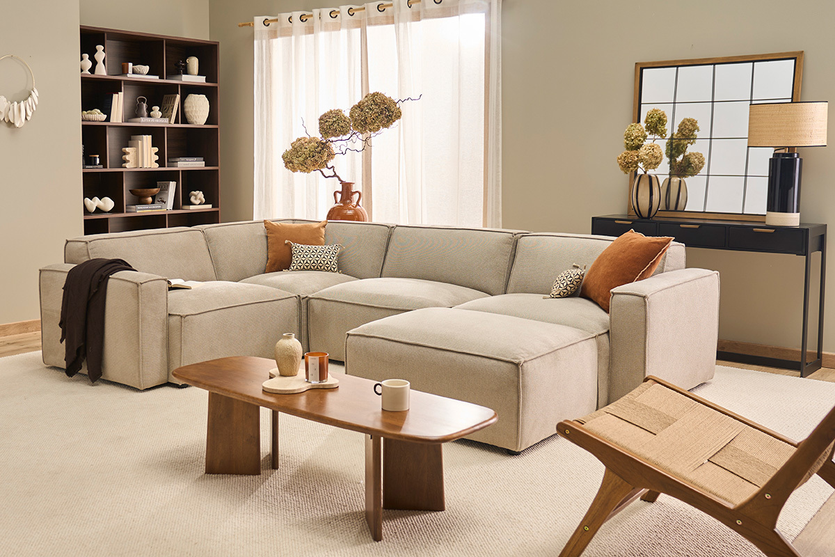 Canap� d'angle beige modulable 5 places avec pouf, salon moderne, table basse et �tag�res.