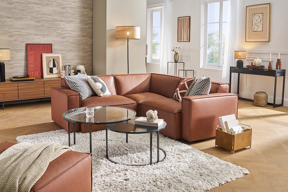 Canap d'angle en cuir marron dans un salon moderne avec table basse et tapis.