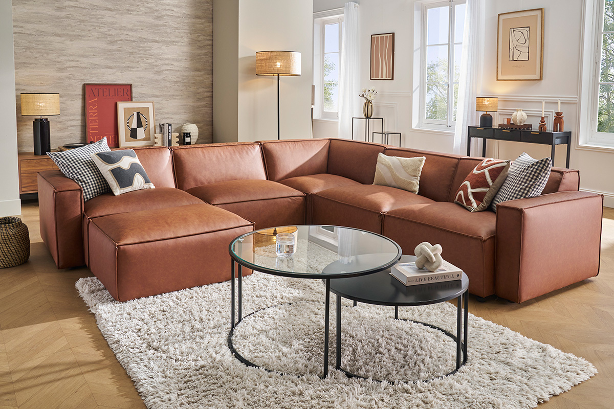 Canap d'angle en cuir marron SPLIT, 5 places et pouf, dans un salon moderne avec table basse ronde.
