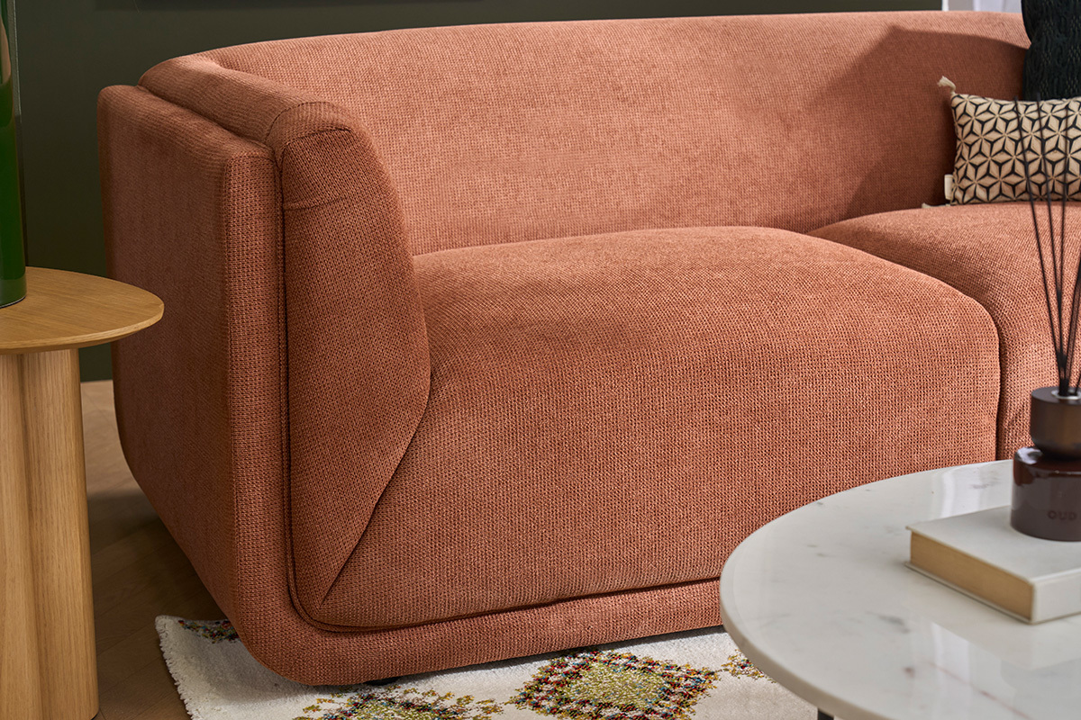 Canap� 3 places en tissu chenille terre br�l�e, vue de c�t�, table en bois � gauche.