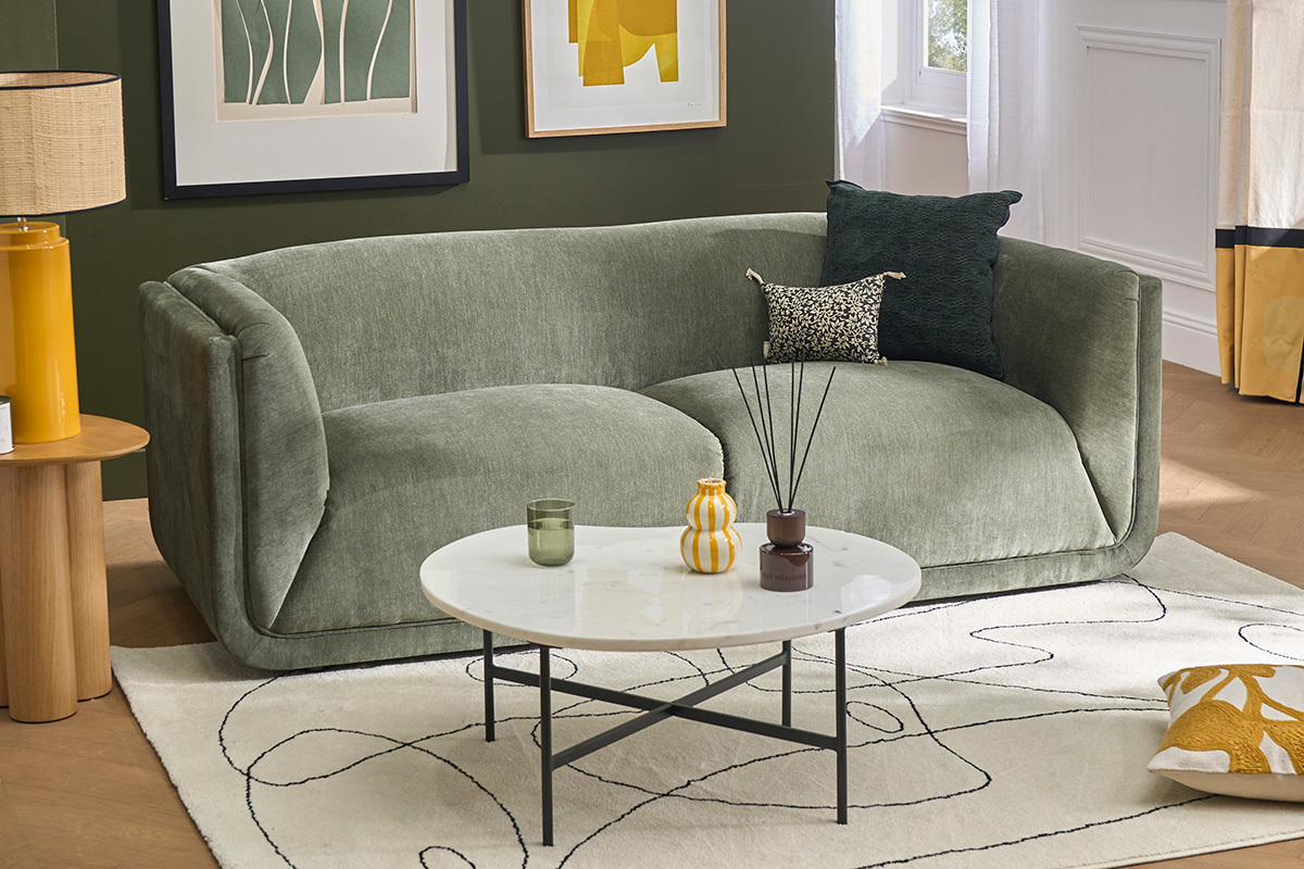 Canap� 3 places vert kaki avec coussins et table basse ronde dans un salon �l�gant.