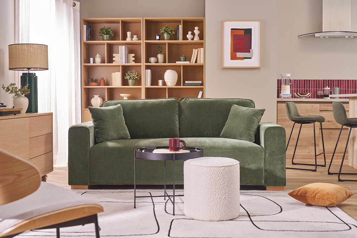 Canap� vert kaki 3 places en tissu effet velours dans un salon moderne avec �tag�res et table basse.