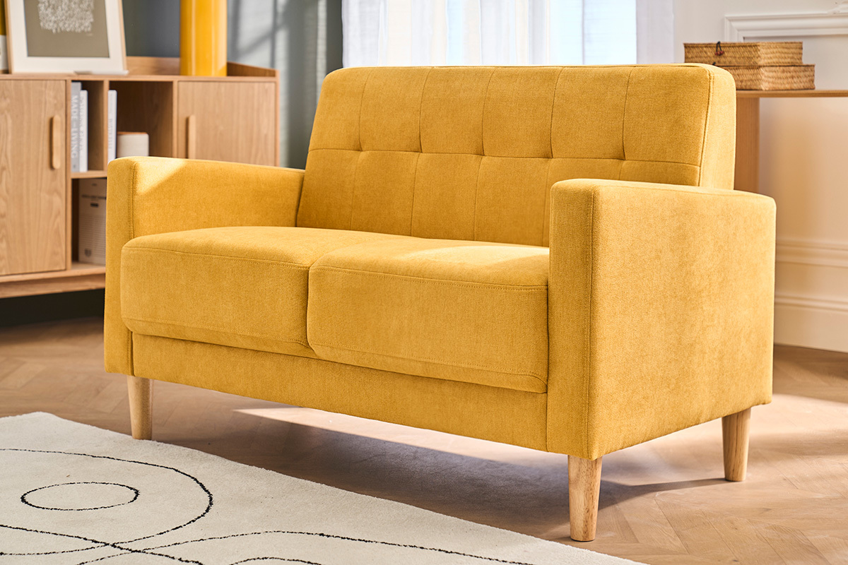 Canap� scandinave 2 places jaune moutarde, pied bois, vue d'angle dans un salon moderne.
