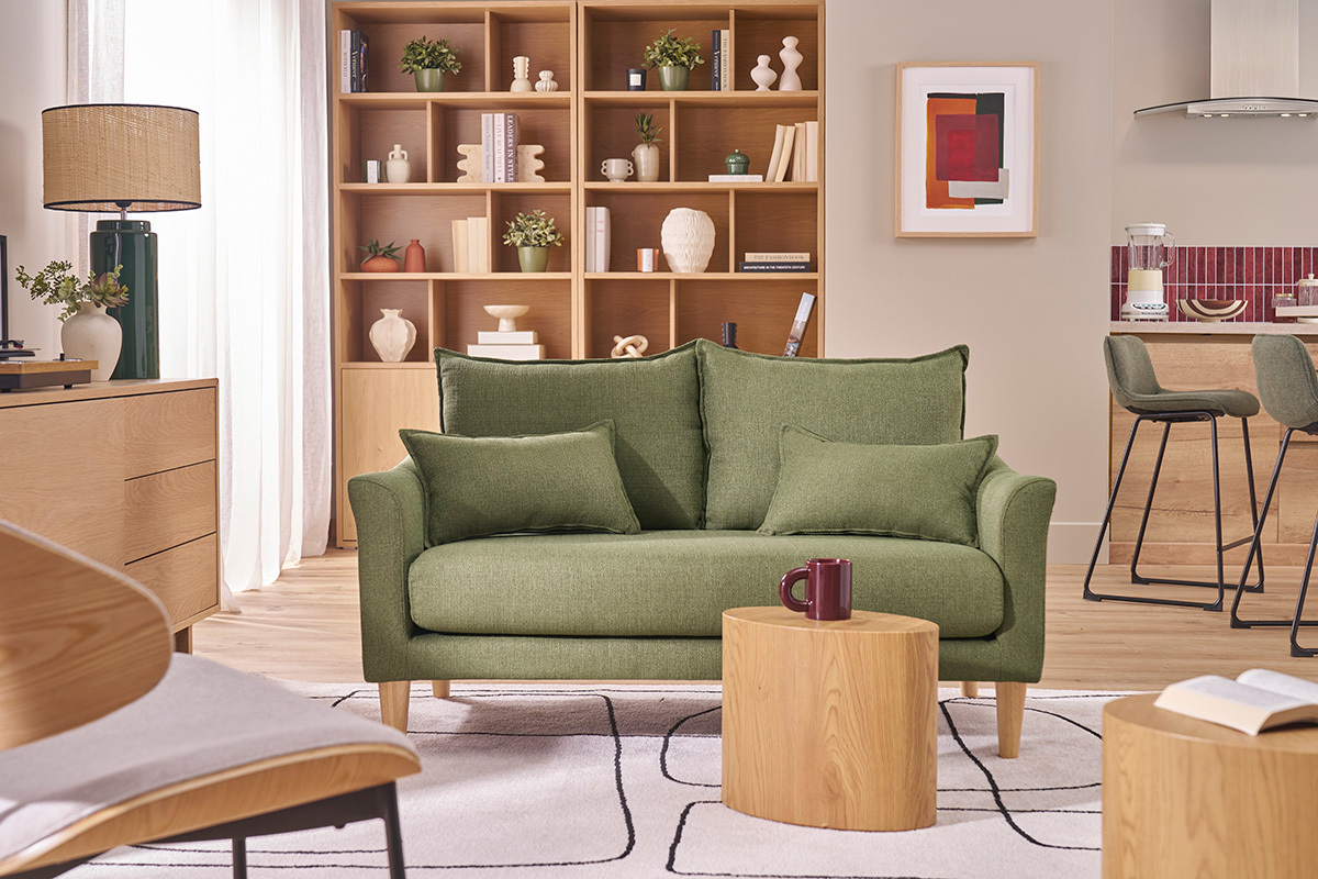 Canap� 2 places en tissu vert kaki avec pieds en bois, situ� dans un salon lumineux.
