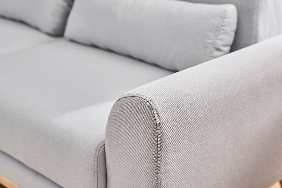 Canap� scandinave 3 places en tissu gris clair, gros plan sur accoudoir et coussins.