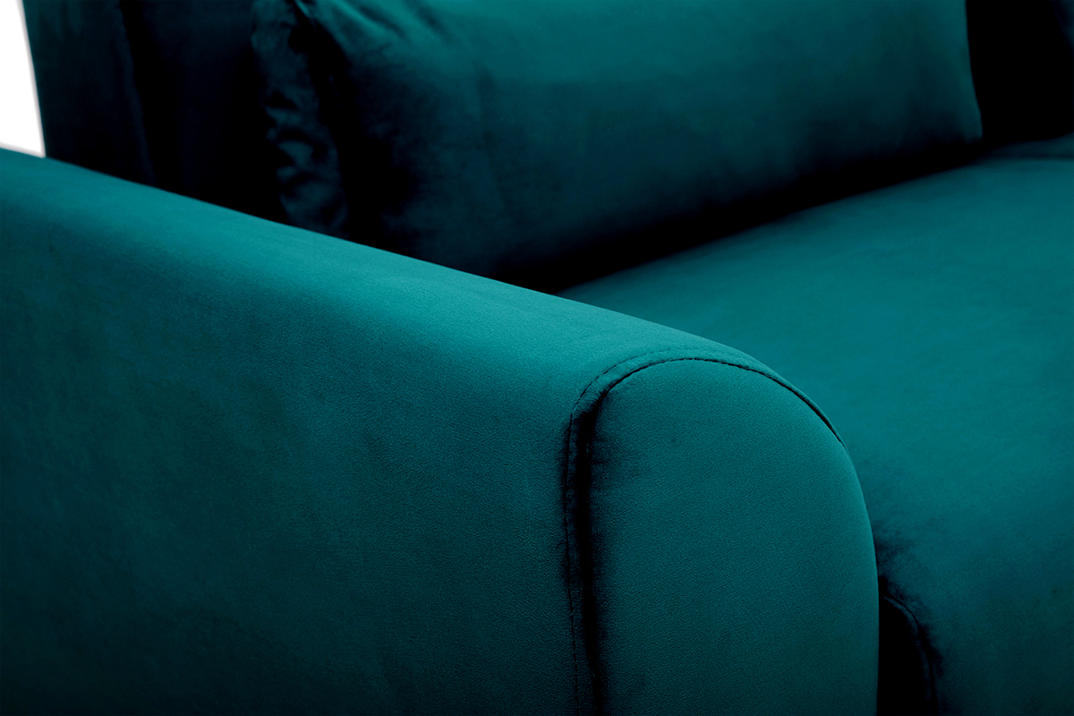 Gros plan sur accoudoir du canap scandinave en velours bleu ptrole.