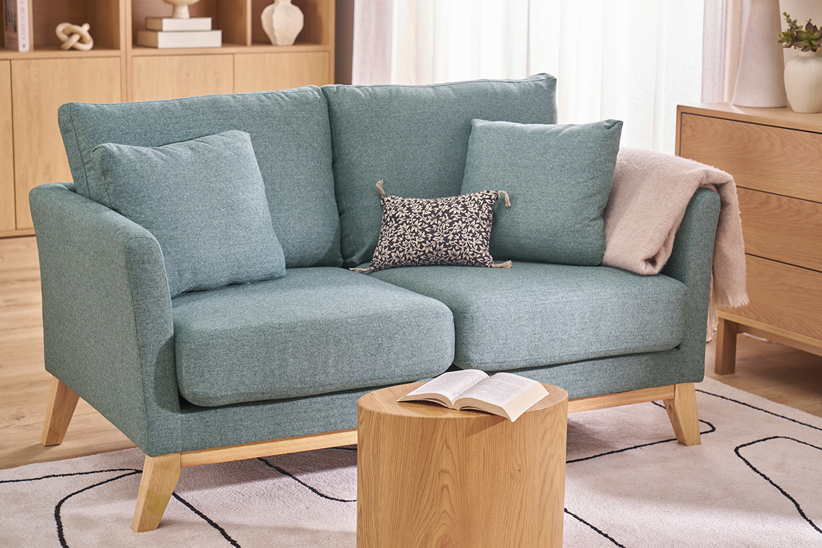 Canap� scandinave 2 places vert de gris avec coussins, table basse devant.