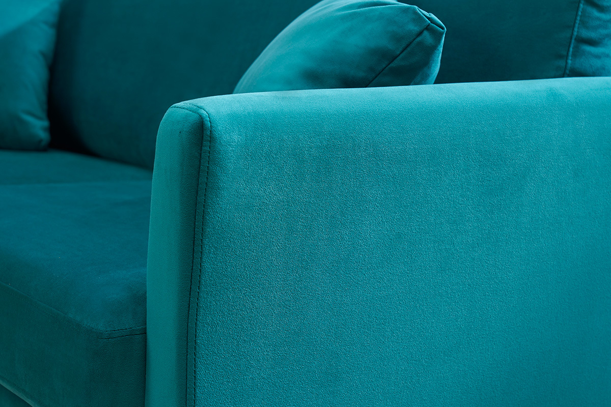 Accoudoir de canap en velours bleu ptrole avec coussin.