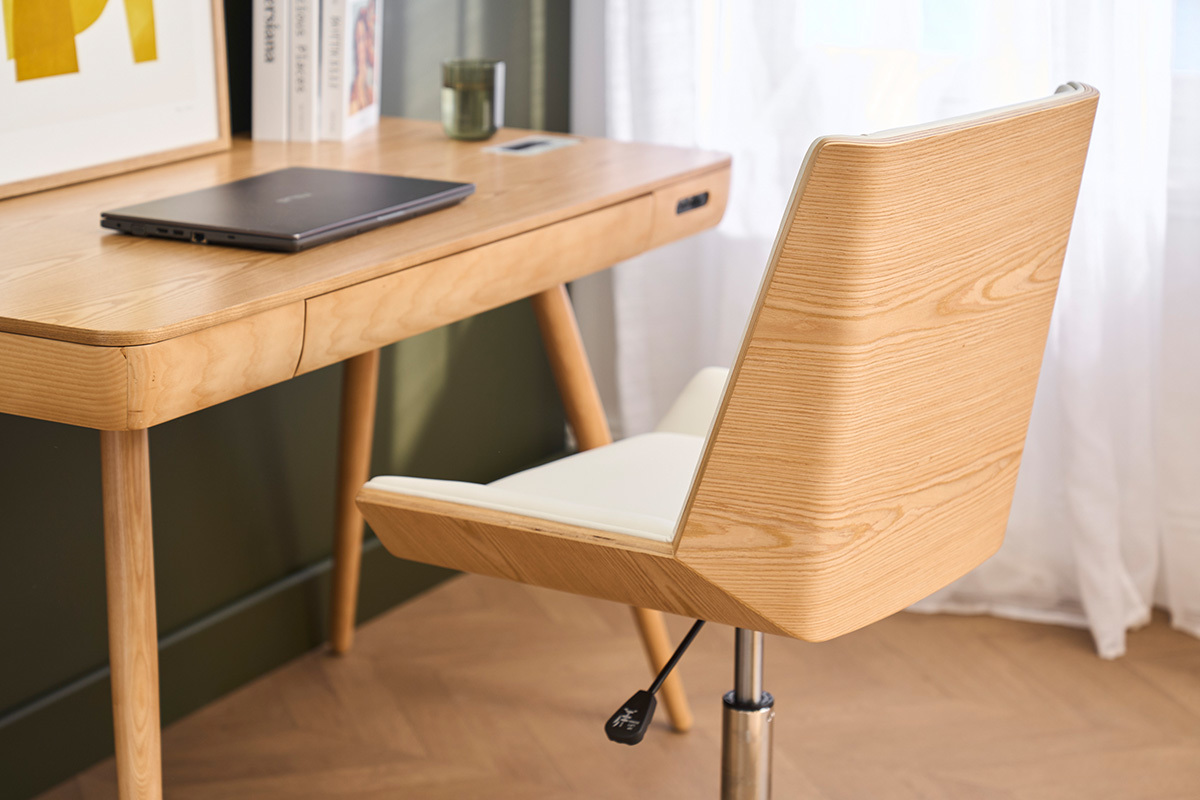 Chaise de bureau � roulettes MELKIOR, bois clair et assise blanche, pr�s d'un bureau en bois.