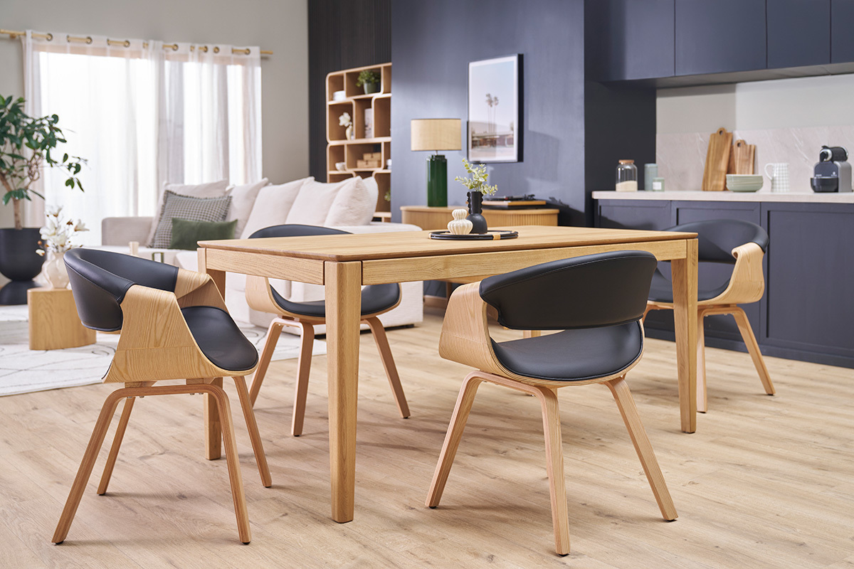 Chaises ARAMIS noires et bois clair autour d'une table  manger dans un salon moderne.