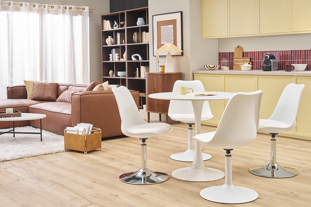 Quatre chaises pivotantes blanches STEEVY V2 autour d'une table blanche, intrieur moderne.