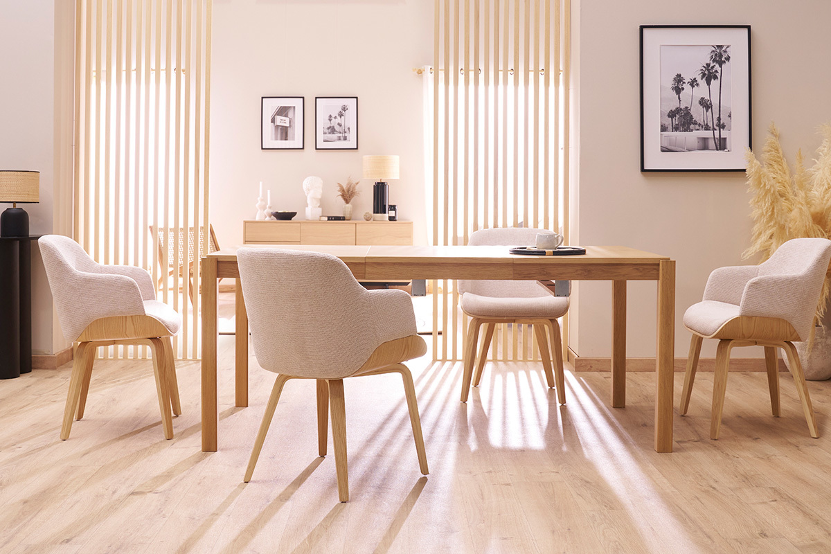 Salle � manger avec quatre chaises EARL en tissu chenille gris et pieds en bois clair autour d'une table en bois.