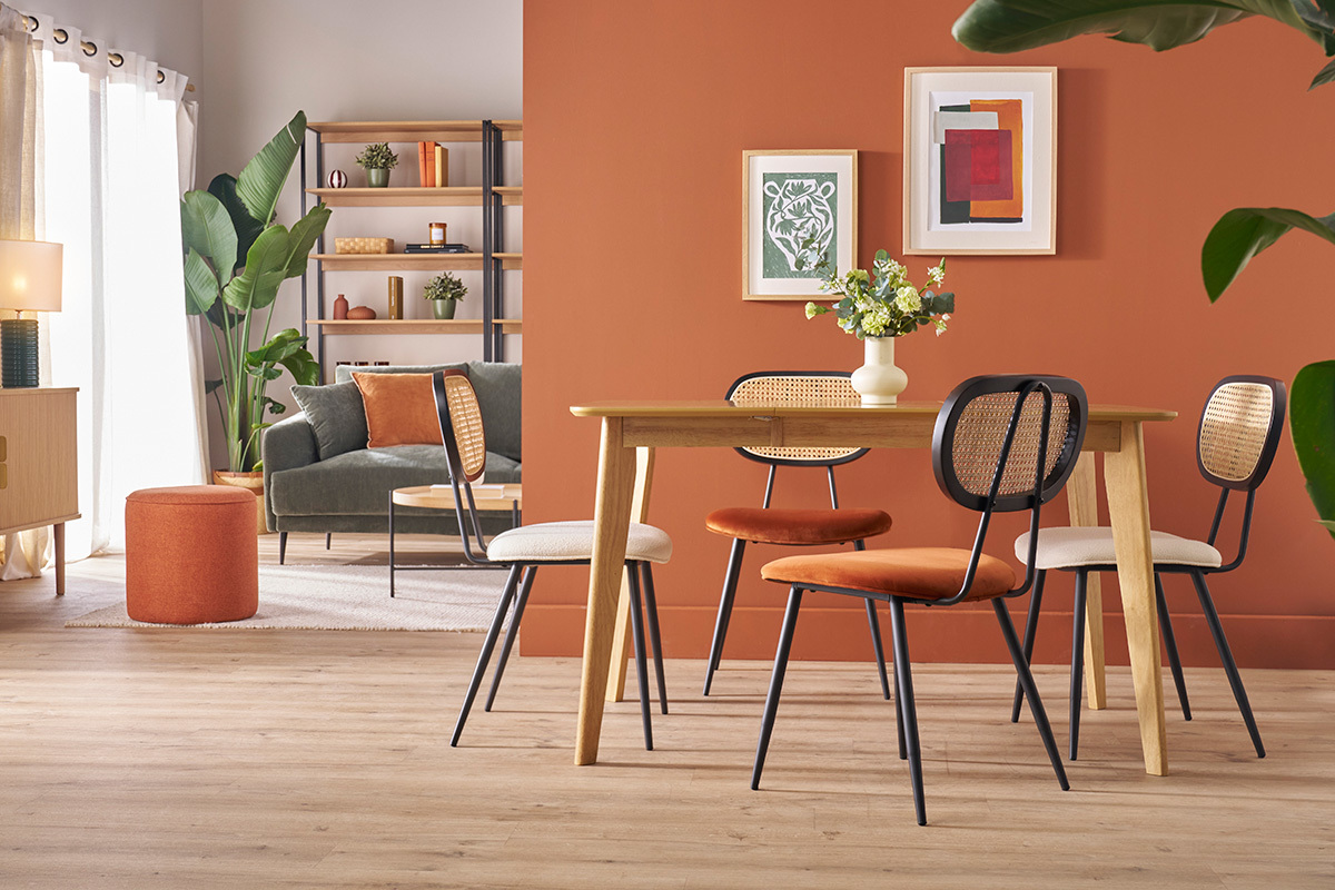 Chaises design en velours terre br�l�e et rotin autour d'une table en bois clair.