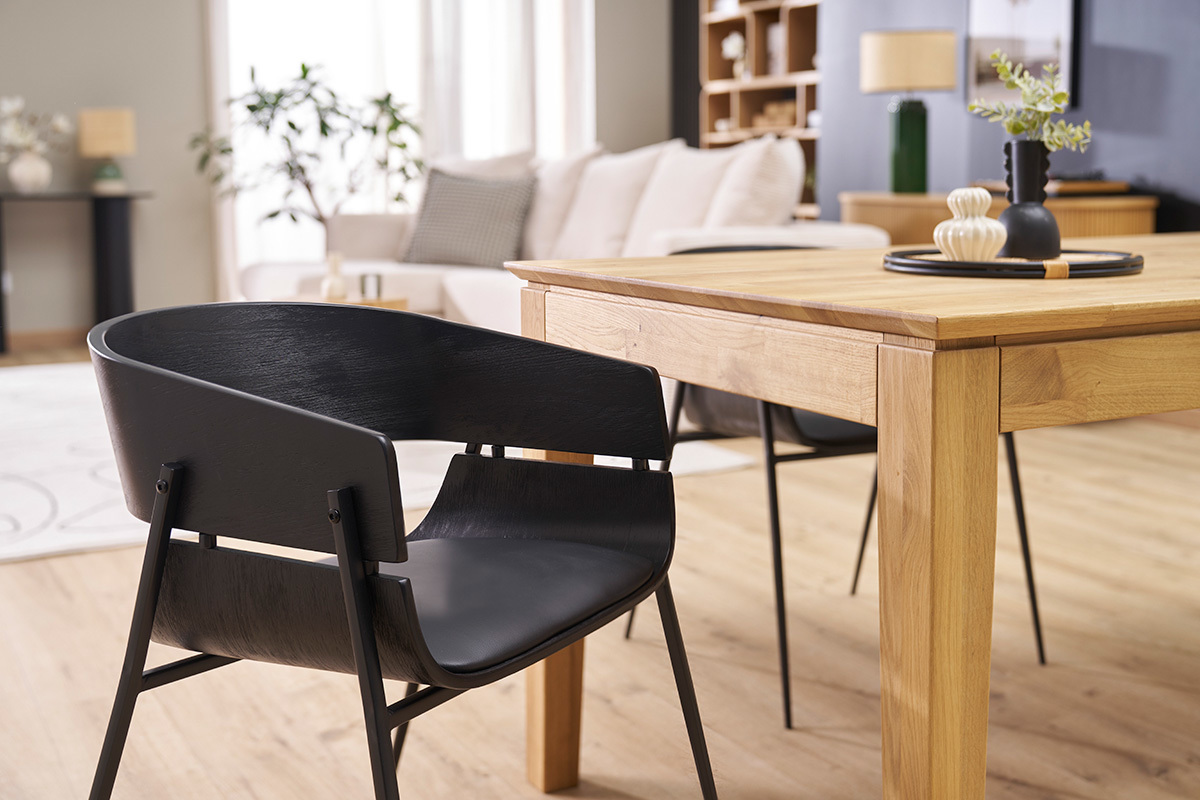 Chaise design noire WESS vue ct prs d'une table en bois dans un salon.
