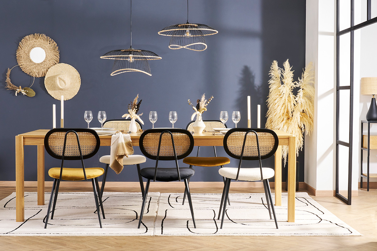 Salle � manger avec chaises SWANN en velours et cannage, autour d'une table en bois.