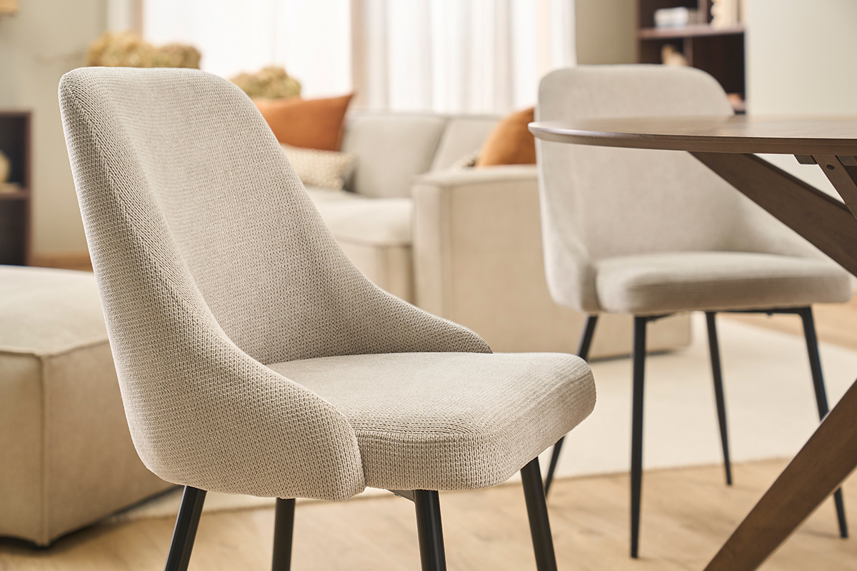 Chaises en tissu chenille beige et m�tal noir, vue d'angle dans un int�rieur.