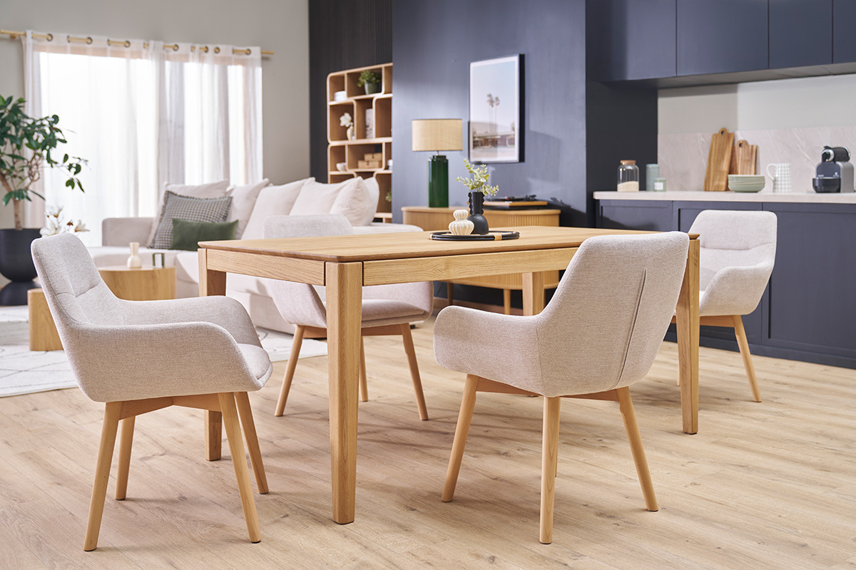 Chaises ALESS en tissu beige et bois clair autour d'une table dans un salon.