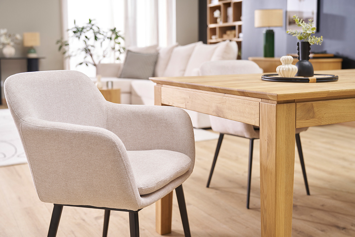 Chaises en tissu beige effet velours et mtal noir, autour d'une table en bois dans un salon contemporain.