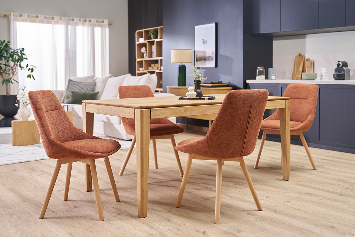 Salle  manger avec chaises ALESS en tissu terre brle et pieds en bois clair autour d'une table.
