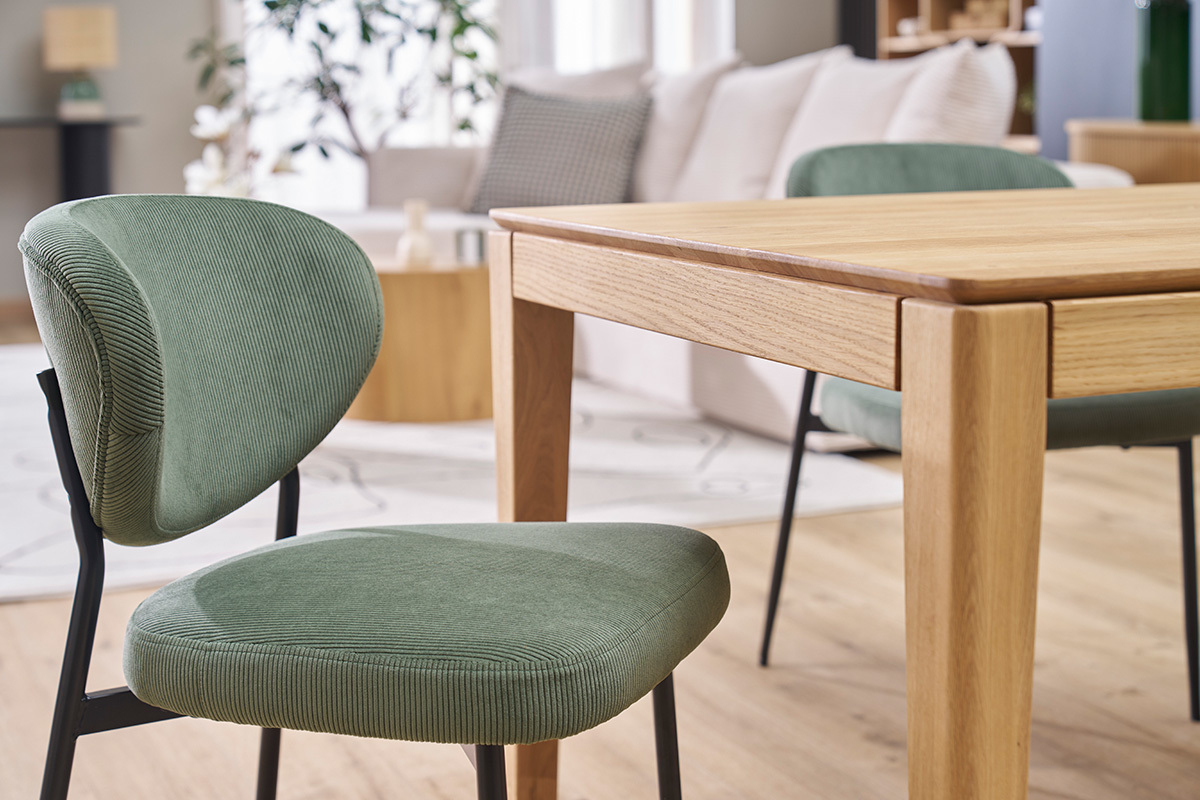 Chaises en velours vert kaki et mtal noir autour d'une table en bois, intrieur moderne.