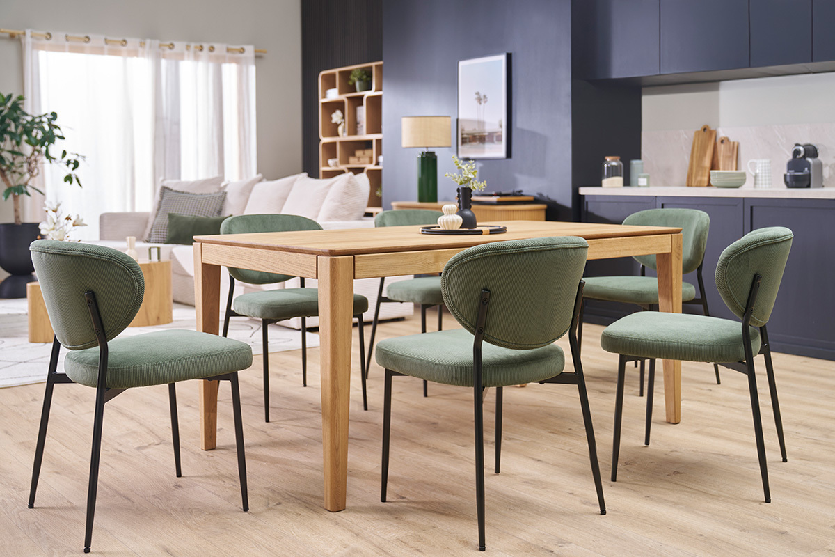 Chaises en velours ctel vert kaki et mtal noir autour d'une table en bois dans une salle  manger.