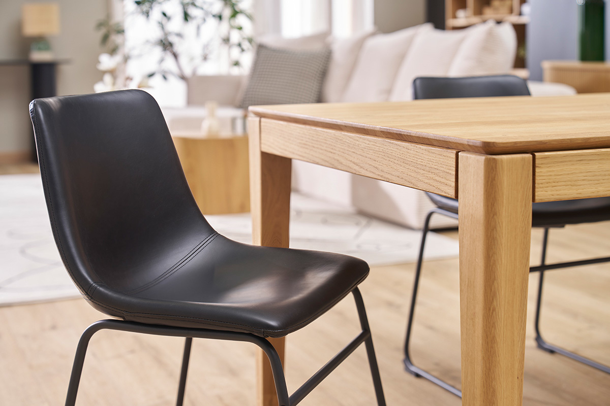 Chaise noire industrielle NEW ROCK devant une table en bois dans un intrieur moderne.