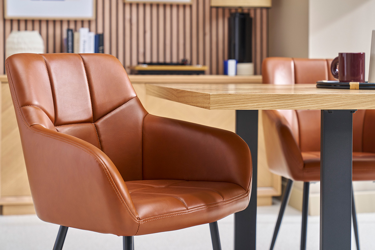 Chaises matelasses marron et mtal noir autour d'une table en bois.