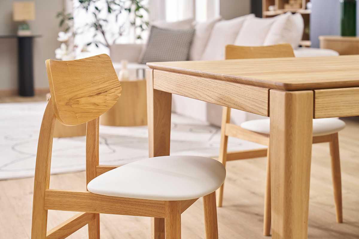 Chaises scandinaves en bois clair avec assise blanche, autour d'une table en bois, intrieur moderne.