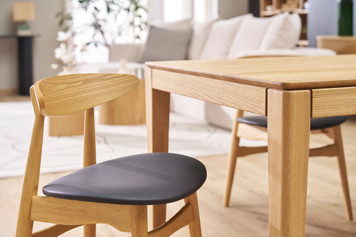 Chaises WALFORD en bois clair et noir autour d'une table en bois clair, vue de ct.