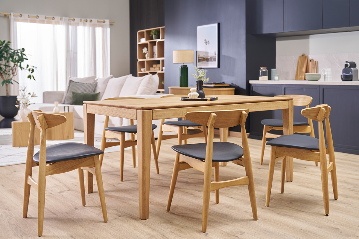 Chaises scandinaves WALFORD en bois clair et noir autour d'une table, dans une salle  manger lumineuse.