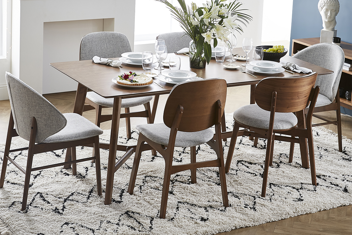 Chaises vintage en bois fonc� noyer autour d'une table, ambiance conviviale de repas.