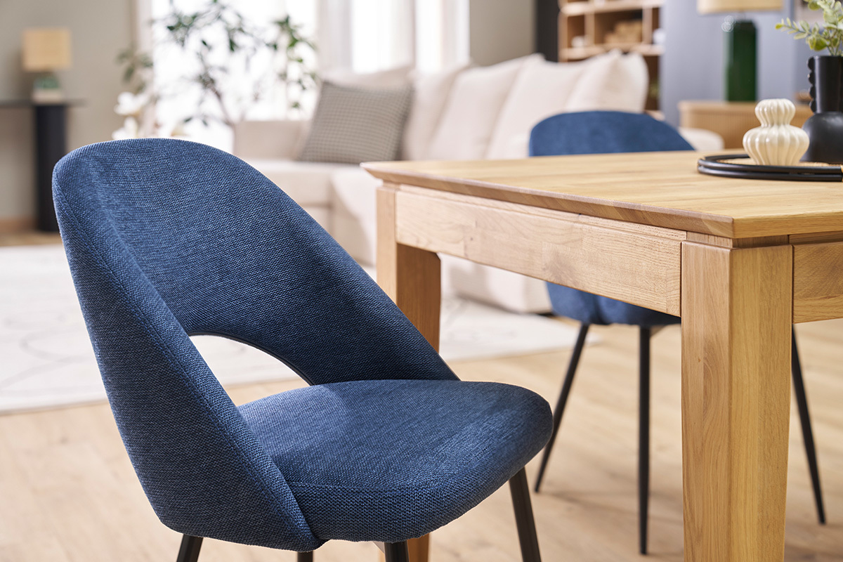 Chaises vintage en tissu bleu avec pieds en mtal noir prs d'une table en bois.