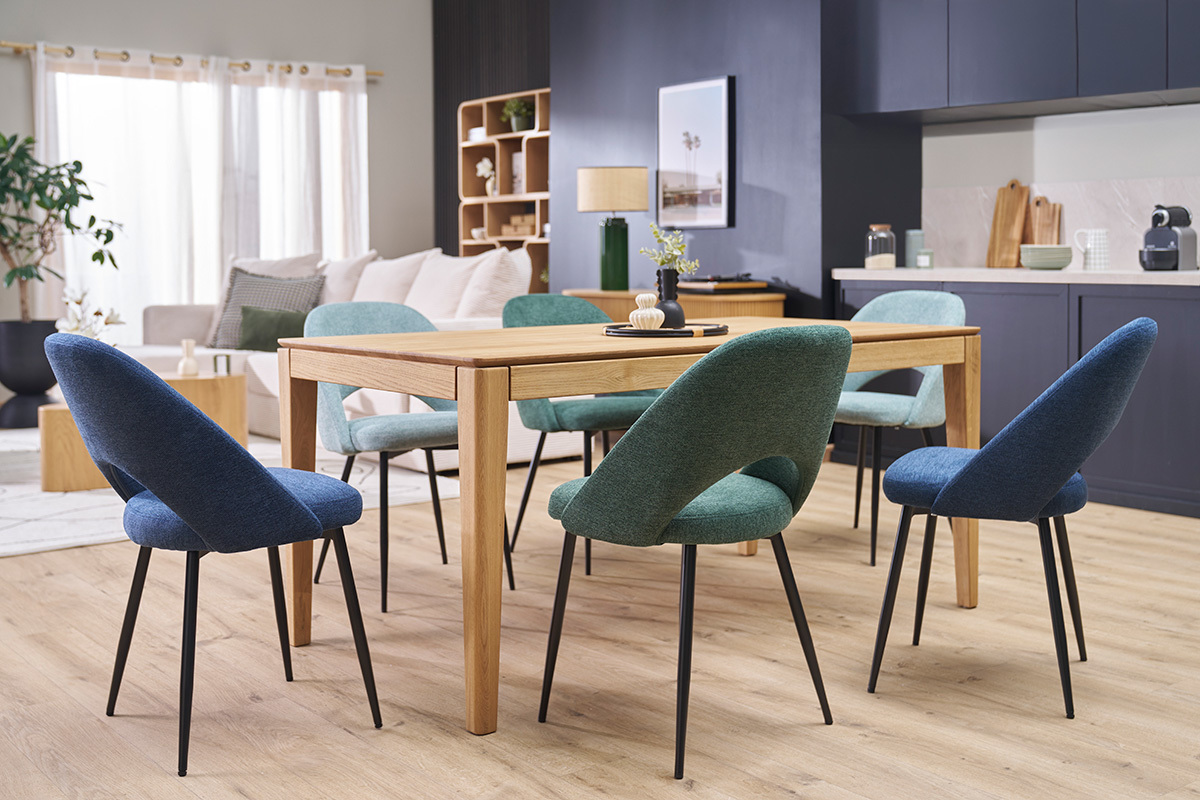 Chaises vintage vertes et bleues autour d'une table en bois dans une salle  manger moderne.