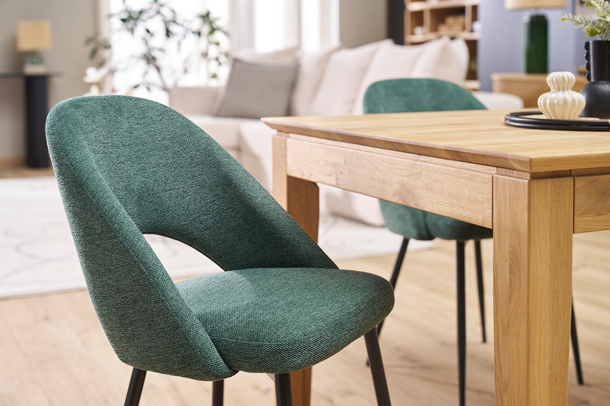 Chaises en tissu vert et mtal noir prs d'une table en bois dans un salon.