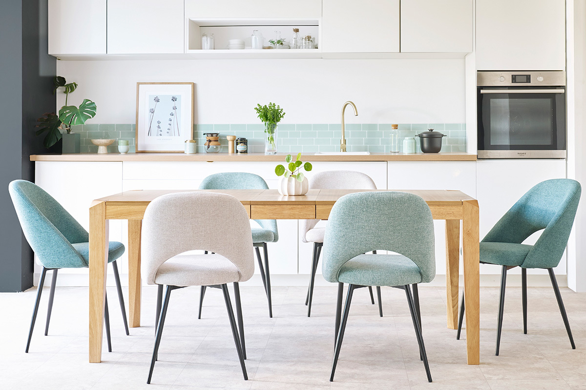 Chaises en tissu autour d'une table en bois dans une cuisine moderne.
