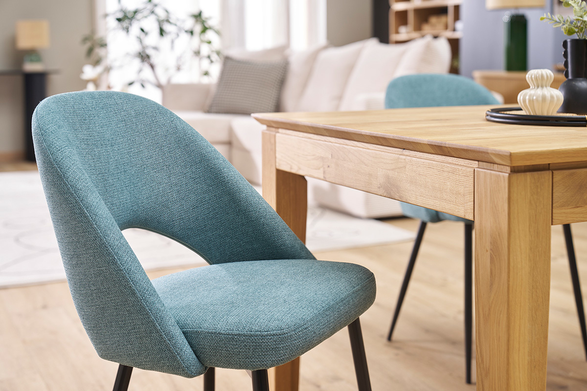 Chaises vintage vert de gris avec pieds en mtal noir,  ct d'une table en bois.